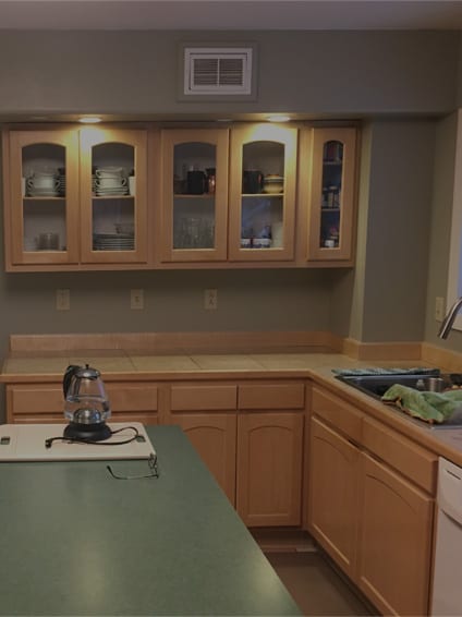 A kitchen with wooden cabinets and green counter tops.