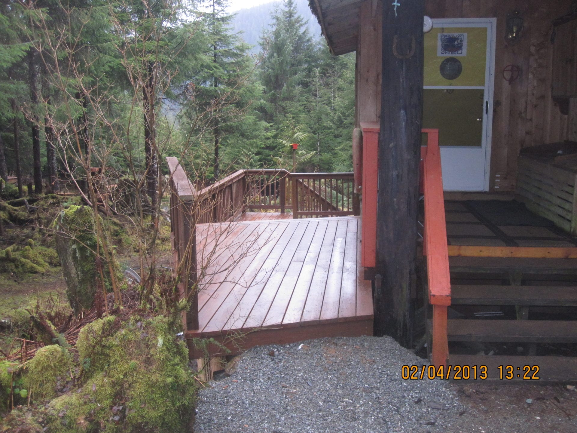 A wooden deck with steps leading to the front door.