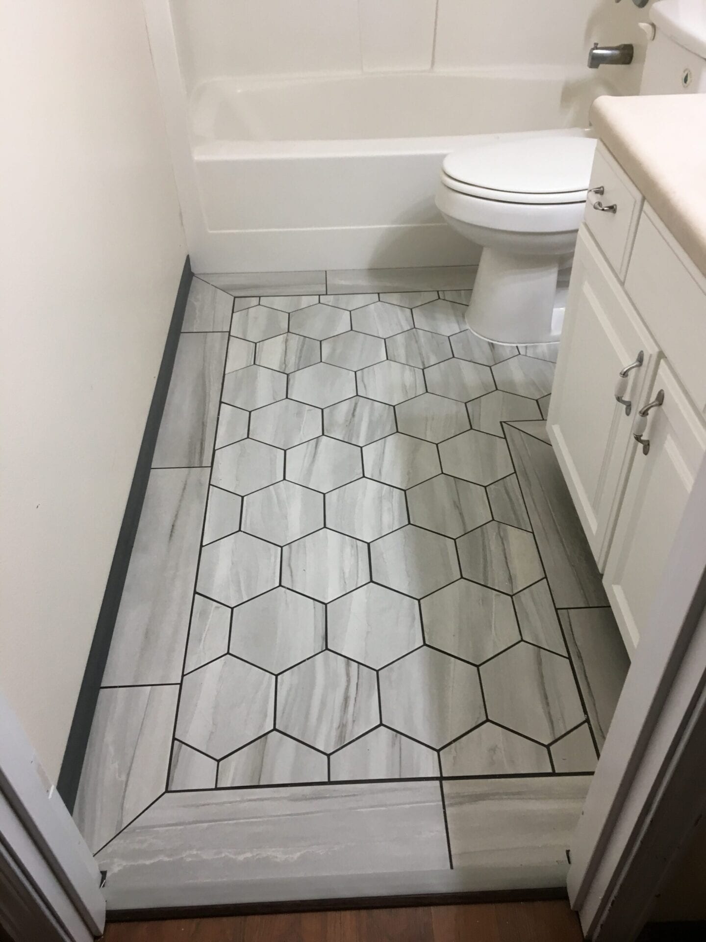 A bathroom with white walls and tile floor.